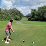 Panoramic view of a lush green golf course at The Club at River Wilderness. Smooth