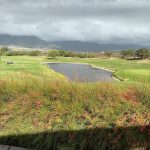 Panoramic view of a lush green golf course at The Dunes at Maui Lani Golf Course. Smooth