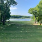 Panoramic view of a lush green golf course at The Golf Club of Oklahoma. Smooth