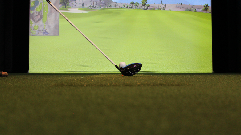 Panoramic view of a lush green golf course at The Golf Room. Smooth