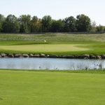 Panoramic view of a lush green golf course at The Highlands of Elgin Golf Course. Smooth