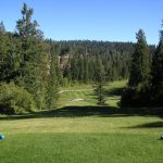 Panoramic view of a lush green golf course at The Lodge Golf Course. Smooth