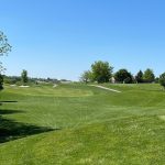 Panoramic view of a lush green golf course at The Meadows Golf Club. Smooth