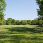 Panoramic view of a lush green golf course at The Mill Course. Smooth