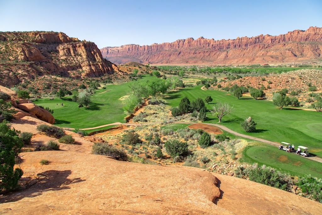 Panoramic view of a lush green golf course at The Moab Golf Course. Smooth