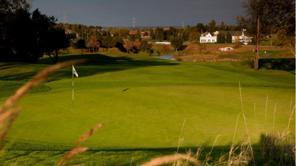 Panoramic view of a lush green golf course at The Orchards Golf Club. Smooth