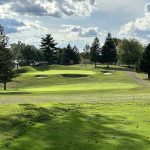 Panoramic view of a lush green golf course at The Pines Country Club. Smooth