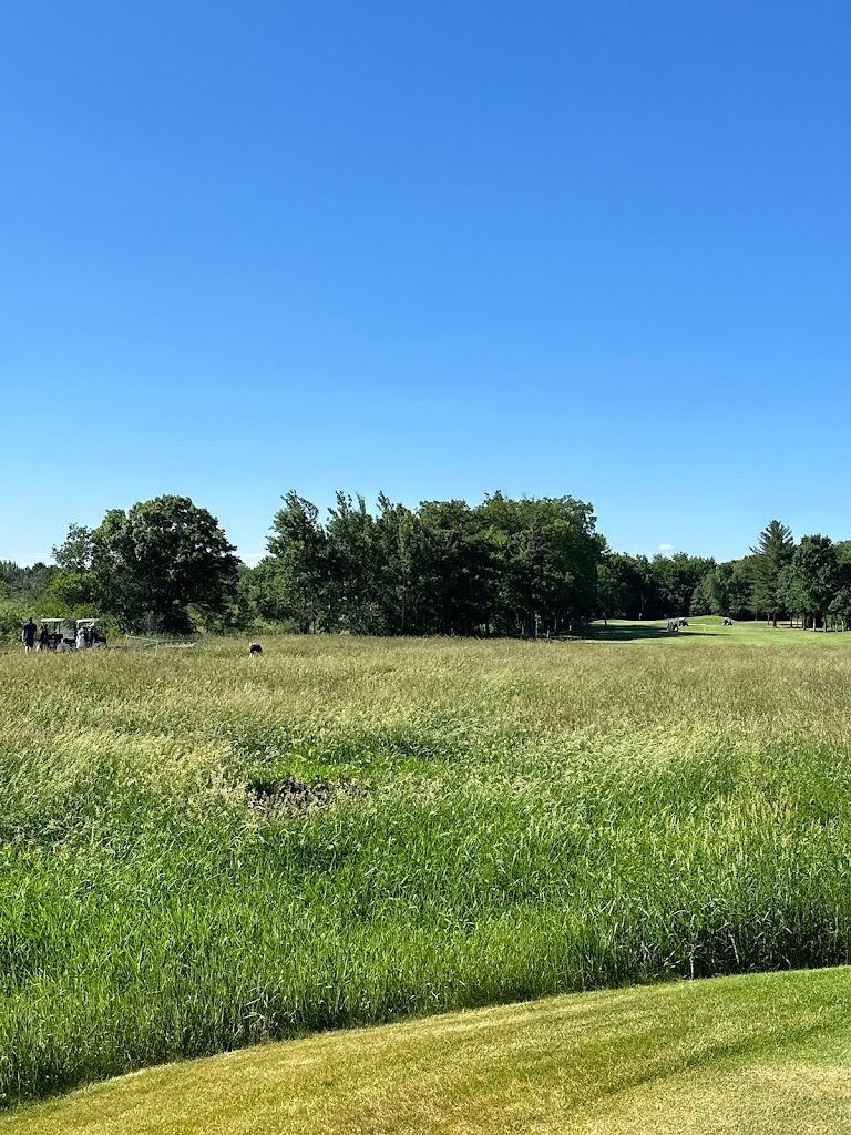 Panoramic view of a lush green golf course at The Refuge Golf Club. Smooth