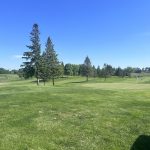 Panoramic view of a lush green golf course at Timber Creek Golf Course. Smooth