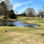 Panoramic view of a lush green golf course at Timber Truss Golf Course. Smooth