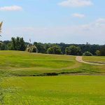 Panoramic view of a lush green golf course at Tishomingo Golf Course. Smooth