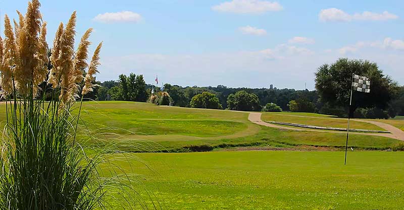 Panoramic view of a lush green golf course at Tishomingo Golf Course. Smooth