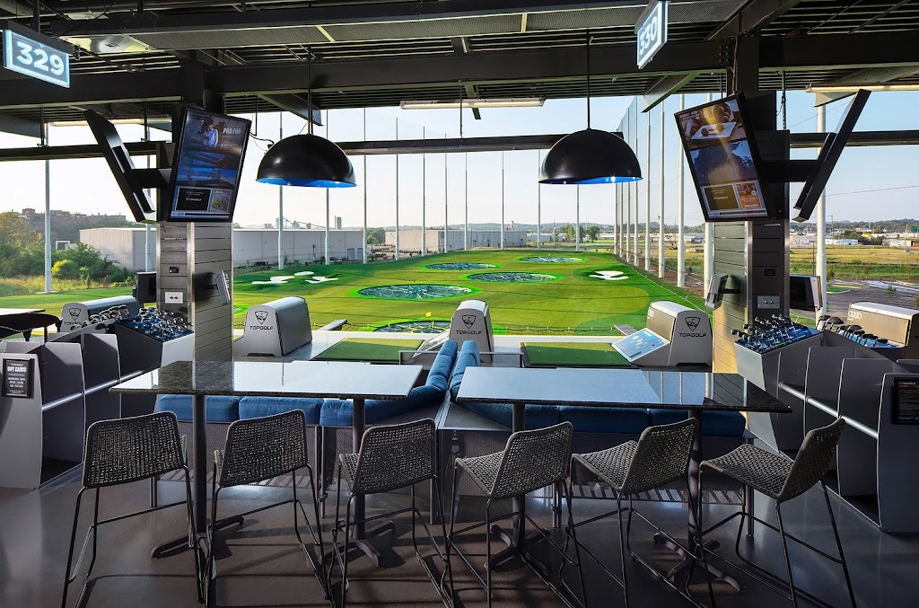 Panoramic view of a lush green golf course at Topgolf Nashville. Smooth