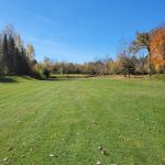 Panoramic view of a lush green golf course at Traditions Golf Club and Learning Center. Smooth