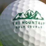 Panoramic view of a lush green golf course at Tri-Mountain Golf Course. Smooth