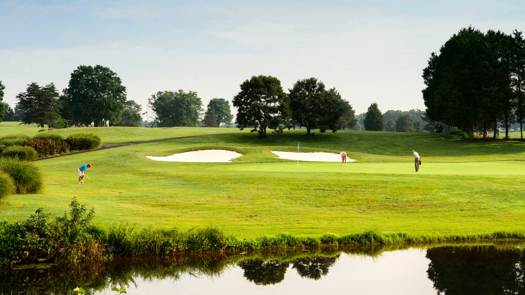 Panoramic view of a lush green golf course at Twin Lakes Golf Course. Smooth