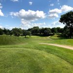 Panoramic view of a lush green golf course at Waveland Golf Course. Smooth