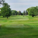 Panoramic view of a lush green golf course at West Branch Country Club. Smooth