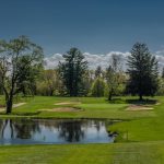 Panoramic view of a lush green golf course at Whip Poor Will Golf Club. Smooth