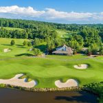 Panoramic view of a lush green golf course at Whiskey Creek Golf Club. Smooth