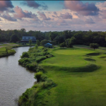 Panoramic view of a lush green golf course at Wilderness Golf Course. Smooth