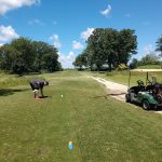 Panoramic view of a lush green golf course at Wildwood Golf Course. Smooth