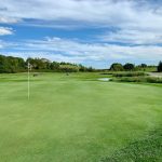 green grass with the flag in the hole.