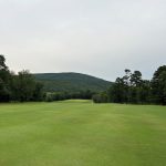 Panoramic view of a lush green golf course at Wolf Mountain. Smooth