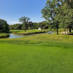 Panoramic view of a lush green golf course at Woods At Cherry Creek. Smooth