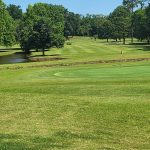 Panoramic view of a lush green golf course at Woodward Golf Club. Smooth